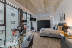 a bedroom with a bed and a glass table at Capitalia Centro Historico in Mexico City