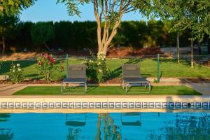 two chairs sitting next to a swimming pool at THE FERNANDEZs HOUSE in Hinojosa del Duque