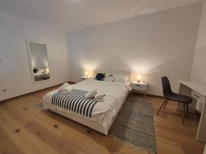 瓦比尼科Apartman Uptown的一间卧室配有一张大床、一张桌子和一把椅子