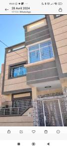 een hoog gebouw met blauwe ramen en een balkon bij Appartement in Oujda