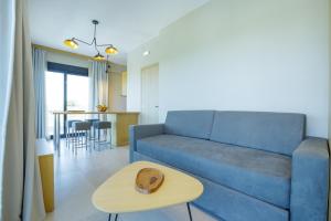 a living room with a blue couch and a table at La Perla Del Campo in Kánalos