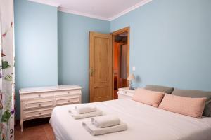 una camera da letto con un letto bianco con asciugamani sopra di Apartamento Ruiloba-Comillas a Casasola