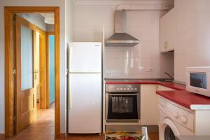 una cucina con frigorifero bianco e forno a microonde di Apartamento Ruiloba-Comillas a Casasola