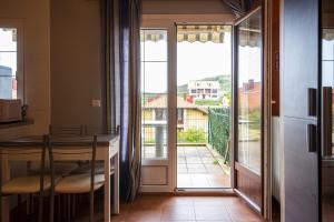 una cucina con tavolo e vista sul balcone di Apartamento Ruiloba-Comillas a Casasola Altre 19 foto