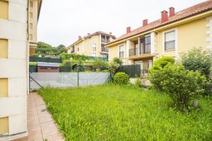 un cortile erboso tra due edifici di Apartamento Ruiloba-Comillas a Casasola