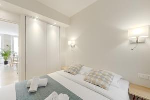 パリにあるジャルダン サント ノレ アパートメンツのベッドと鏡のある白い寝室