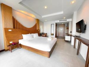 a bedroom with a large bed and a flat screen tv at Dusit Buncha Koh Tao by Riya Group in Ko Tao