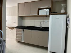 una cucina con mobili bianchi e un frigorifero bianco di Flats Prime a Juazeiro do Norte