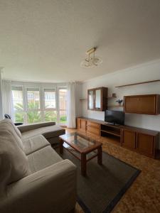 a living room with a couch and a coffee table at Apartamento con vistas al mar playa Berria-Santoña in Santoña