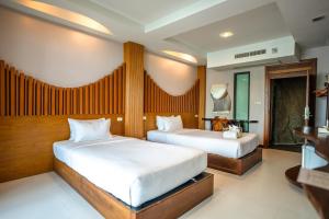 two beds in a hotel room with two bedsvisor at Dusit Buncha Koh Tao by Riya Group in Ko Tao