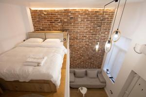 a small room with a bed and a brick wall at Banffy's little house in Cluj-Napoca