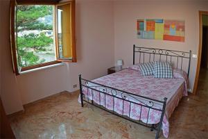 Schlafzimmer mit einem Bett und einem Fenster in der Unterkunft Sopra La Spiaggia in Bogliasco