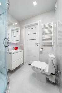 a bathroom with a toilet and a sink and a shower at Apartament Stella in Częstochowa +15 photos