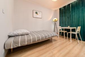 a bedroom with a bed and a table with a green curtain at Apartament Stella in Częstochowa