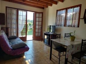 a living room with a couch and a table at Gîte des Lauriers Roses - Piscine collective, Spas et jardins privés - 7 kms de la plage de Lespecier in Bias