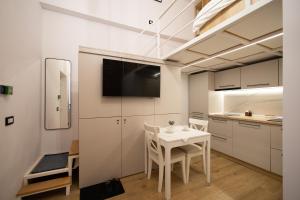 a small white kitchen with a table and a tv at Banffy's little house in Cluj-Napoca