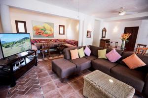 un salon avec un canapé et une télévision à écran plat dans l'établissement Punta Marina Casa 7, à Zihuatanejo