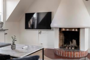 a living room with a fireplace and a tv on the wall at Cozy 3 -bedroom apartment in middle of Visby in Visby