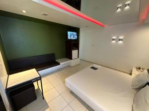 a room with two beds and a tv on the wall at Nop's Motel in Brasilia