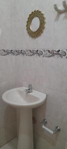 bagno con lavandino e specchio a parete di HOSTAL CARACOLI - HUECO a Valledupar