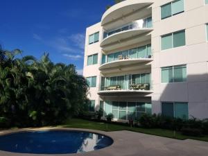 a building with a swimming pool in front of it at Perfectly located spacious apartment with 2 balconies in Ixtapa