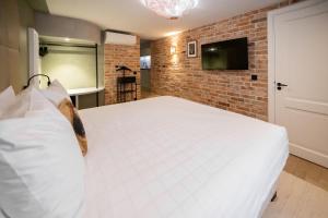 ein Schlafzimmer mit einem weißen Bett und einer Ziegelwand in der Unterkunft De Ware Jacob Boutique Hotel in Amsterdam