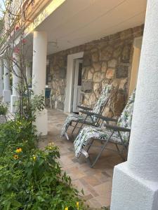 two chairs on a porch with a stone wall at Apartment Anić in Šmrika