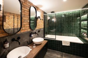 a bathroom with two sinks and a tub and mirrors at De Ware Jacob Boutique Hotel in Amsterdam