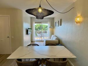a dining room with a table and chairs and a living room at Apartamento Puerto Miramar in Cambrils