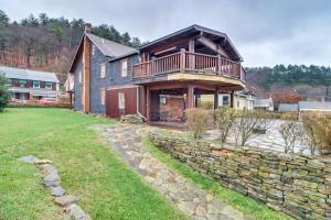 a house with a balcony on top of a stone wall at Charming and Historic Home with Lehigh River View in Parryville