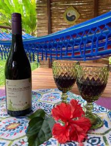 a bottle of wine and two glasses on a table at A Treehouse the Green Frog Romantic setting & Pool in Puerto Viejo
