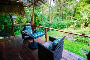 a porch with a table and chairs on a deck at A Treehouse the Green Frog Romantic setting & Pool in Puerto Viejo