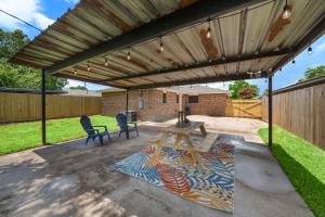 een houten pergola boven een patio met een picknicktafel bij Charming Coastal Retreat in Seabrook TX in Seabrook