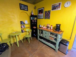 a room with a yellow wall with a table and chairs at Pelican Spa in Truth or Consequences
