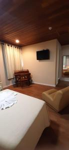 a bedroom with a bed and a flat screen tv at Skalla Hotel Nova Odessa in Nova Odessa +70 photos
