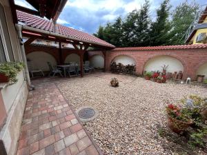 a courtyard with a patio with a table and chairs at Pacsirta Apartmanház in Eger