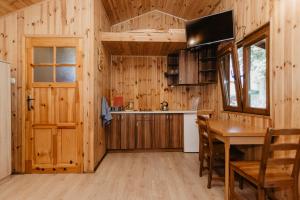 a kitchen and dining room with a table and a television at Gospodarstwo Agroturystyczne z BASENEM & SPA i Alpakami in Ełk