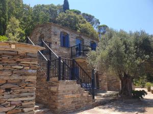 a stone house with stairs and a tree at Moratika Farmhouse in Agios Kirykos