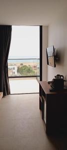 a living room with a large window and a television at Casa del mar in Agadir nʼ Aït Sa