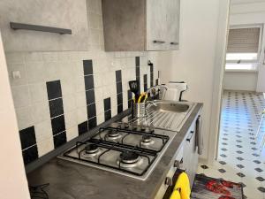 a kitchen with a stove top and a sink at A due passi dal mare in Santa Marinella