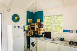 a kitchen with a white refrigerator and a dishwasher at Bungalow Saphir in Le Gosier