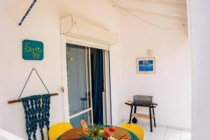 a room with a table and yellow chairs and a window at Bungalow Saphir in Le Gosier +14 photos