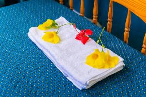 a white towel with flowers on it on a table at Bungalow Saphir in Le Gosier