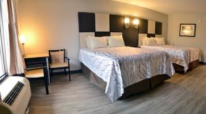 a hotel room with two beds and a desk at Best Western Cades Cove Inn in Townsend