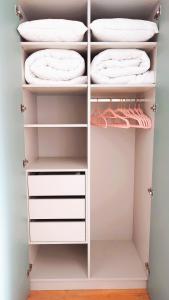 a closet with white shelves and white towels at Apartmán NAD RIEKOU in Bešeňová