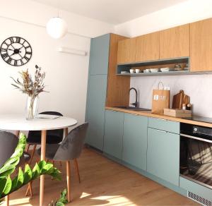 a kitchen with blue cabinets and a table at Apartmán NAD RIEKOU in Bešeňová +20 photos