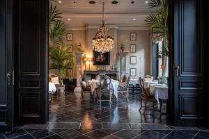 a dining room with tables and chairs and a chandelier at Cobergher Hotel in Kortrijk