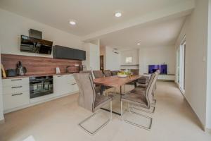 Una cocina con una mesa y sillas de madera. en Apartment Sky Murter, en Murter