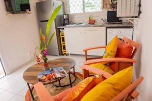 a living room with a table and a kitchen at Bungalow Rubis in Le Gosier