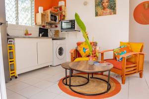 a kitchen with a table and chairs in a kitchen at Bungalow Rubis in Le Gosier +14 photos